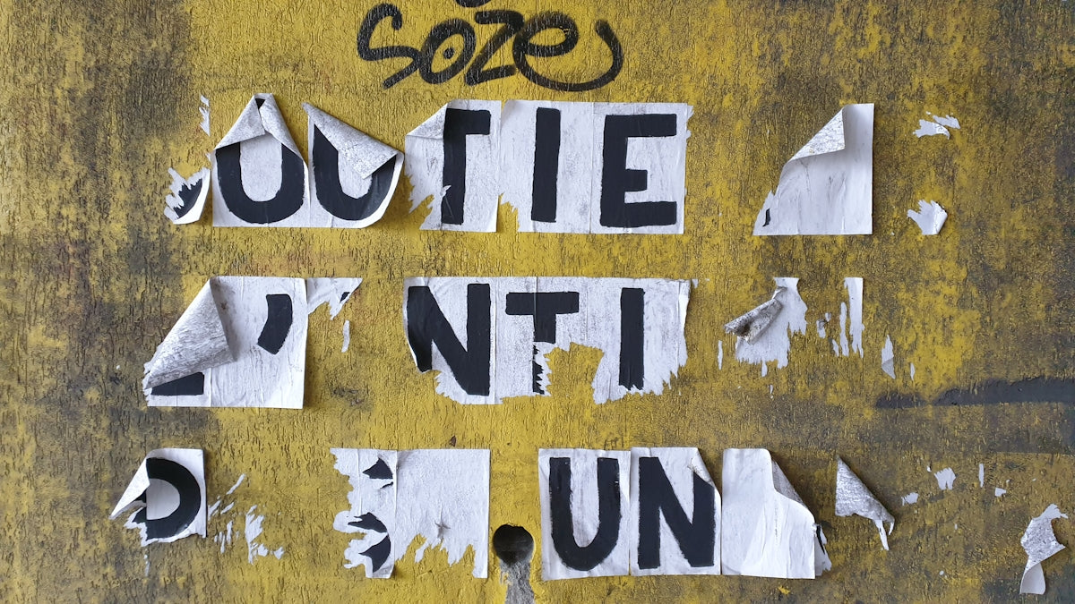 a bunch of torn up pieces of paper sitting on top of a yellow wall