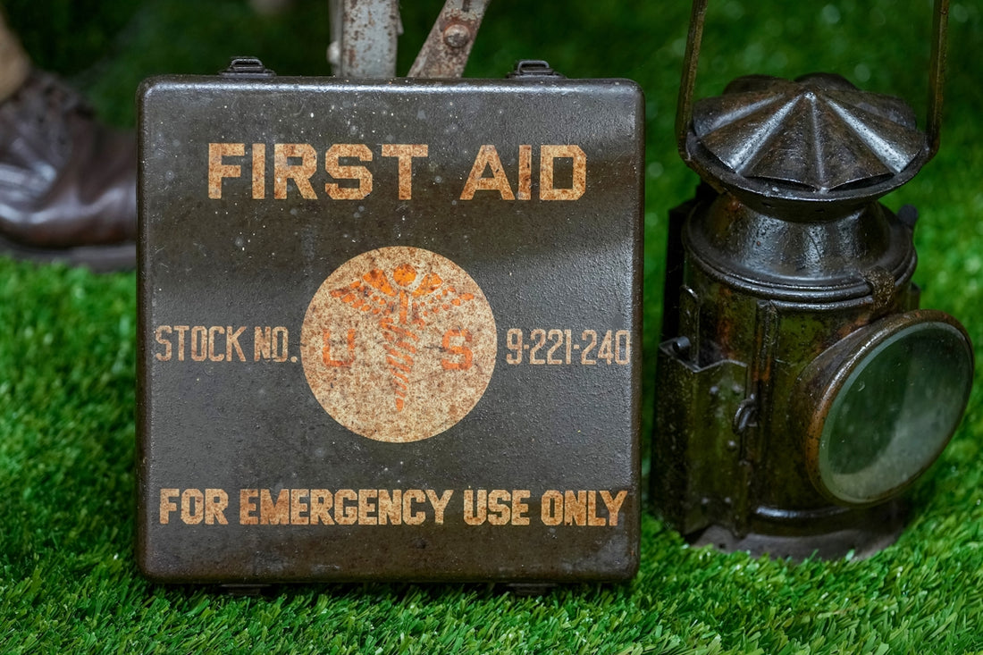 Vintage first aid kit and lantern on grass