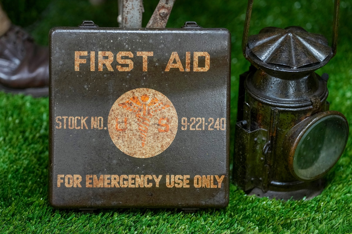 Vintage first aid kit and lantern on grass