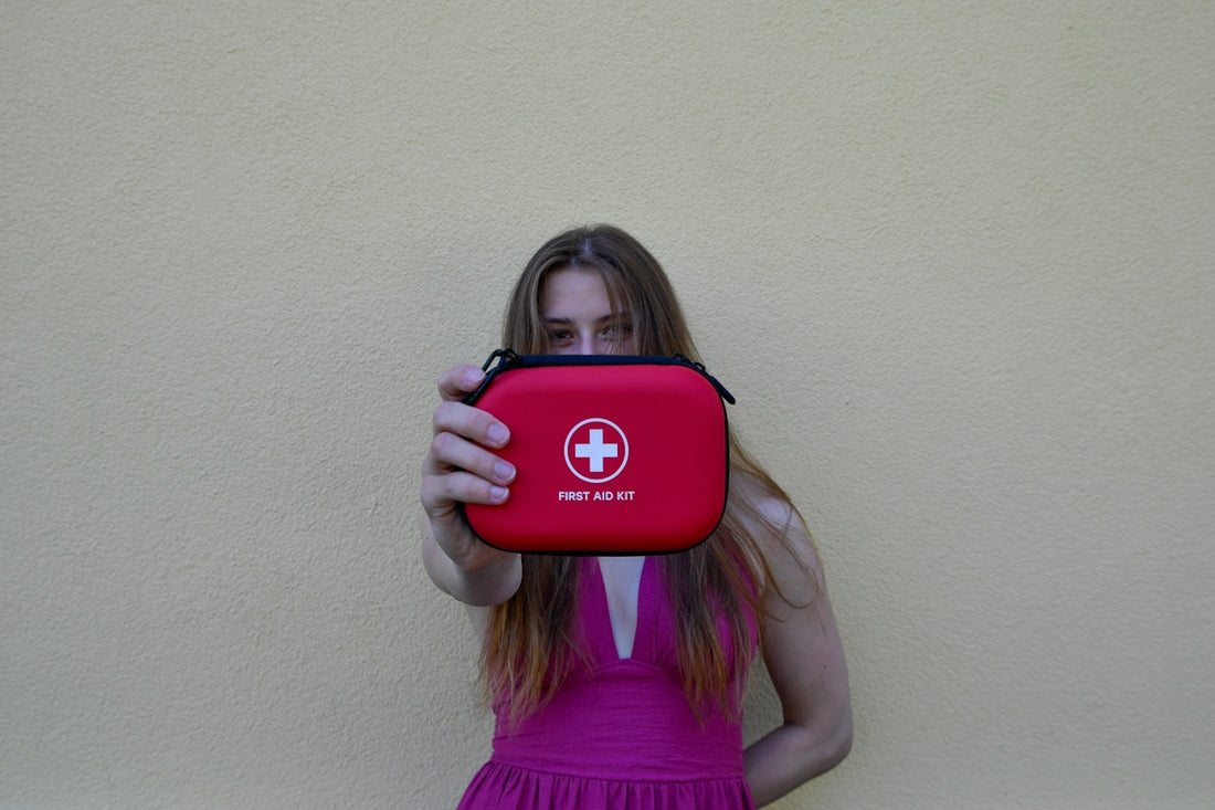 Woman holding a red first aid kit.