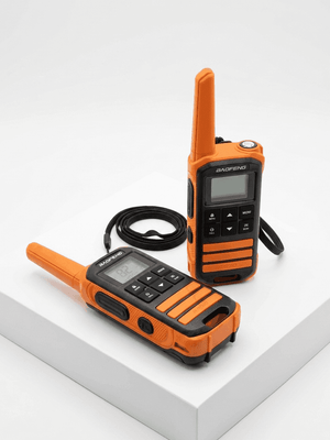 Two orange walkie-talkies on a white surface
